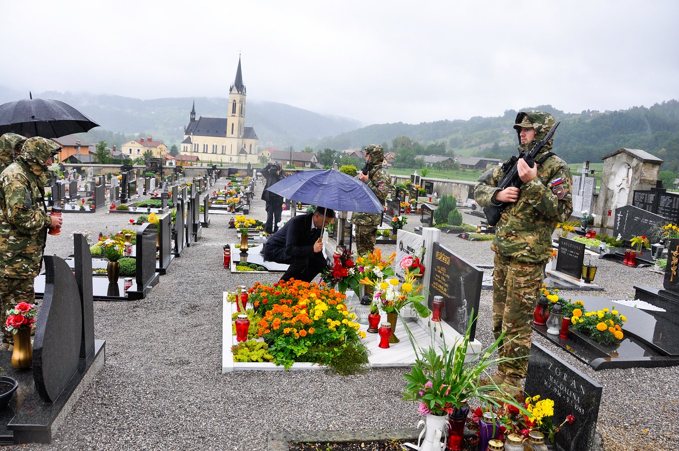 Polaganje cvetja na pokopališču v Prečni