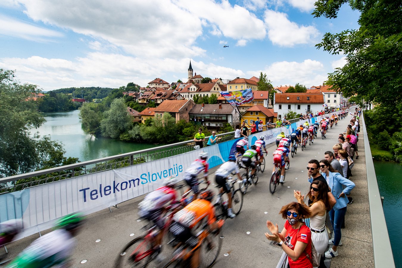 kolesarji se peljejo čez most Vabljeni na zaključek Dirke po Sloveniji v Novo mesto