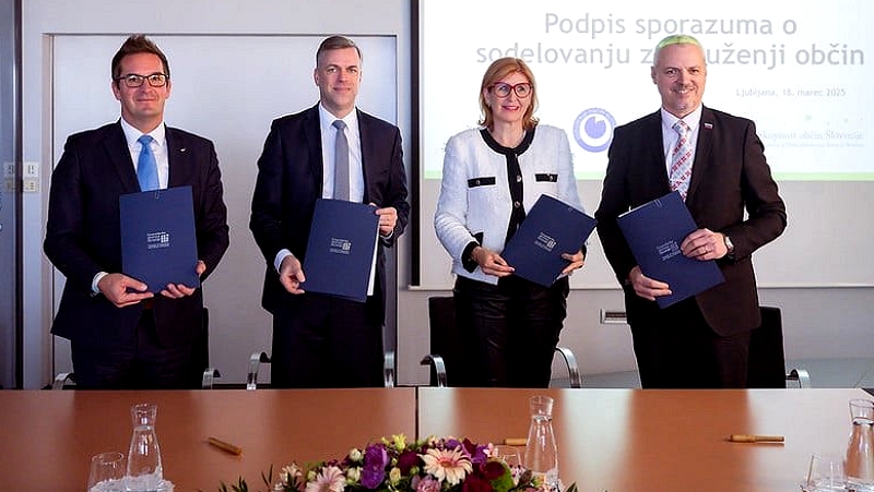 Predstavniki podpisa stojijo in v rokah držijo mape