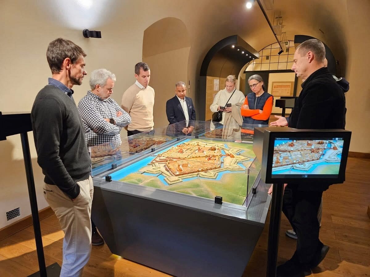 udeleženci stojijo in se ogledujejo reliefni zemlejvid udeleženci stojijo in se ogledujejo reliefni zemlejvid