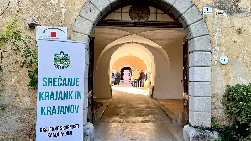 Na fotografiji je plakat KS Kandija-Grm Srečanje krajanov na gradu Grm: veliko smeha in sosedske topline